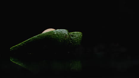 Slow-motion-avocado-with-a-stone-falls-and-breaks-into-2-parts-with-splashes.
